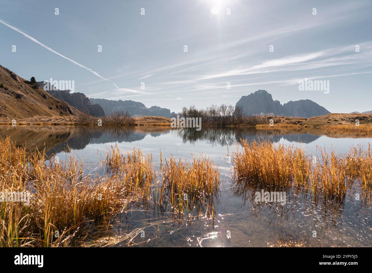 Paesaggio con un lago alpino in primo piano e una catena montuosa in primo piano in una giornata di sole Foto Stock
