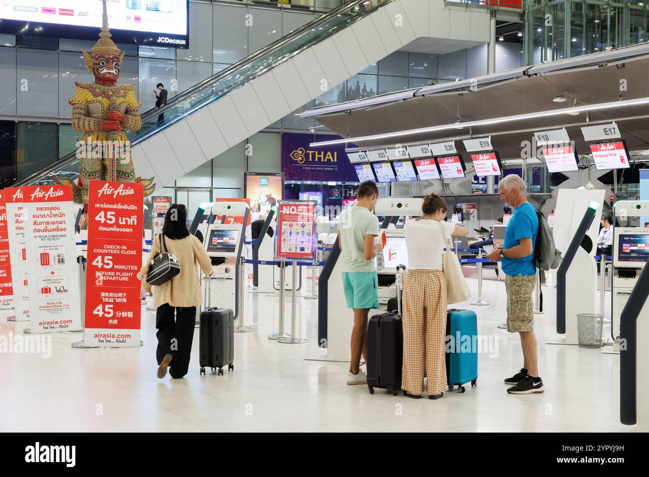 Bangkok, Tailandia - 22 novembre 2024: Check-in familiare per turismo, biglietteria self-service per aerei e donna viaggiatrice che va al gate di partenza in suv Foto Stock