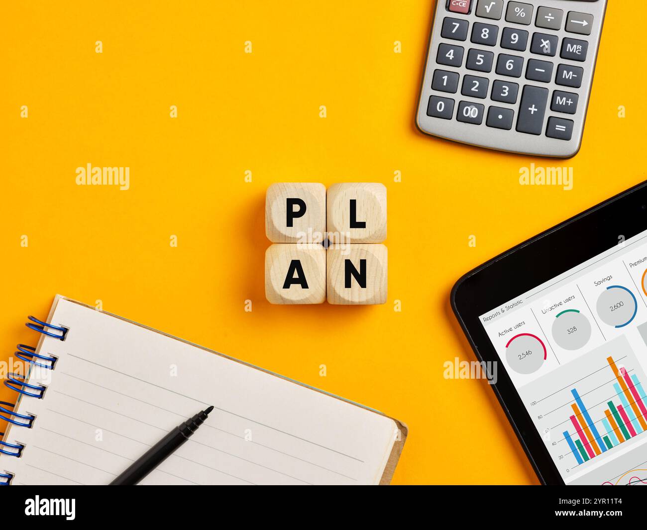 Piano finanziario aziendale, definizione del budget e concetto di strategia. La parola "pianta" su cubi di legno su sfondo giallo per scrivania. Foto Stock