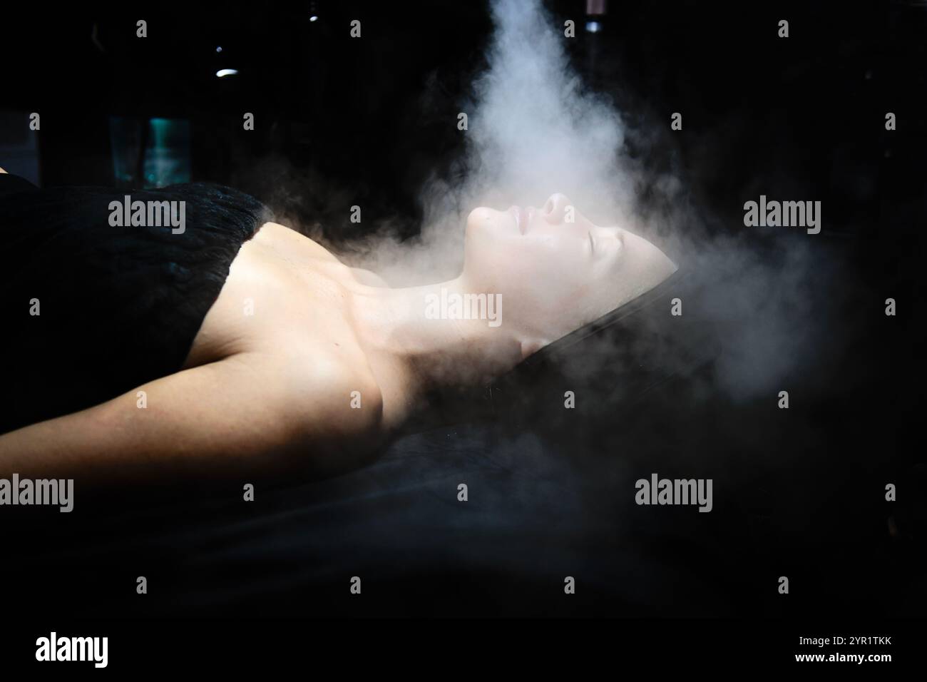 Una donna serena che si gode un rilassante trattamento viso a vapore. Foto Stock