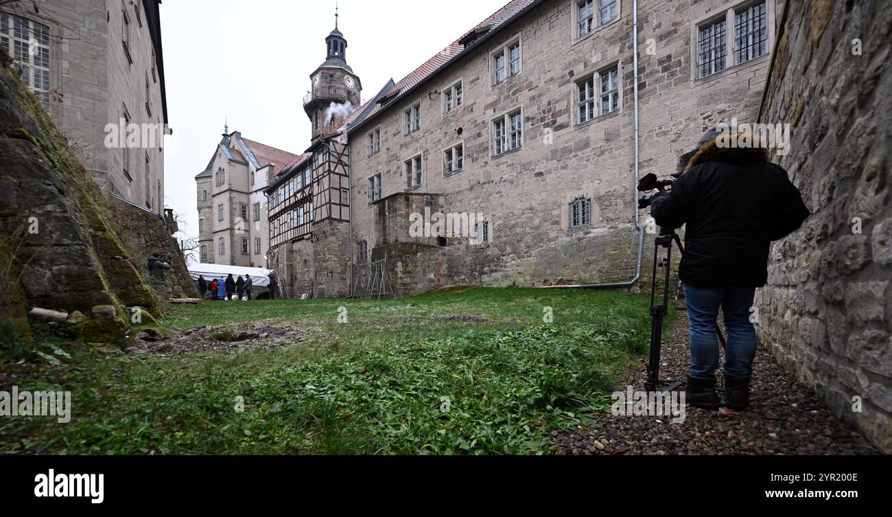 Schleusingen, Germania. 2 dicembre 2024. Un cameraman filma il castello di Bertholdsburg. La Fondazione Turingia Palazzi e Giardini presenta lo stato attuale del programma speciale di investimento durante un tour stampa. Il programma (SIP i), finanziato dal governo federale e dallo Stato libero di Turingia, ha un volume totale di 200 milioni di euro. Dei 23 progetti individuali del SIP i, i primi due sono già stati completati e la costruzione è attualmente in corso su nove siti. Crediti: Martin Schutt/dpa/Alamy Live News Foto Stock