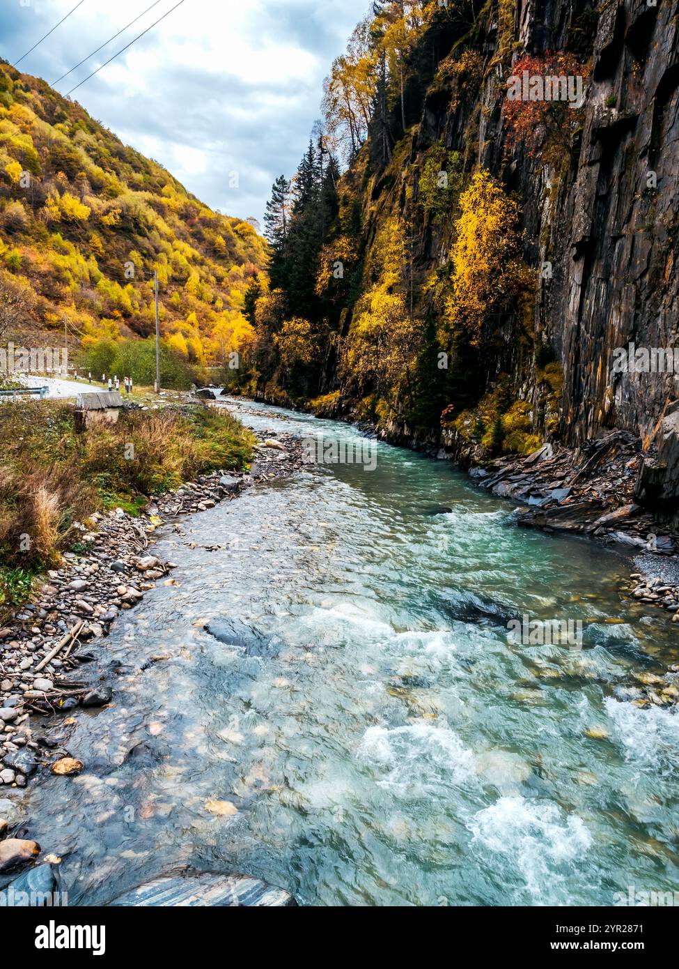 Incredibile paesaggio con ruscelli d'acqua dolce, splendido fiume curvo, montagna verde gialla della foresta su cielo blu con nuvole in autunno in Georgia. Natura m Foto Stock