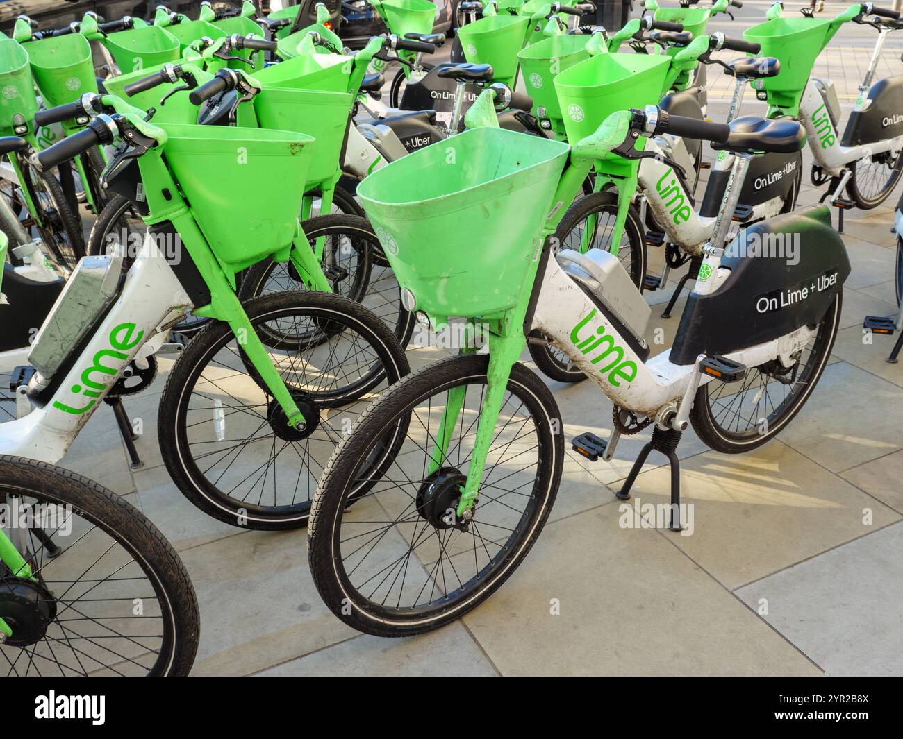 Lime e-bike parcheggiate sulla strada, Londra, Regno Unito Foto Stock