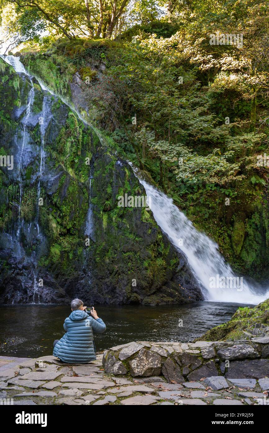 Regno Unito, Galles, Gwynedd, Snowdonia, Llanberis, Coed Victoria, i visitatori si sono seduti accanto alla piscina con cascata Ceunant Fawr Foto Stock
