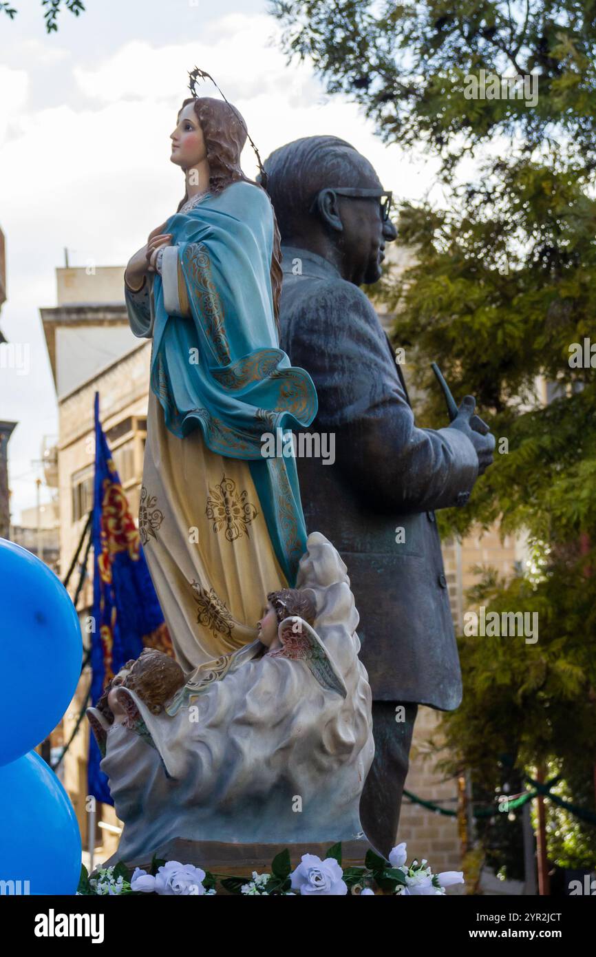 Cospicua, Malta - 1 dicembre 2024. Statua con figure religiose nell'ambiente urbano all'aperto Foto Stock