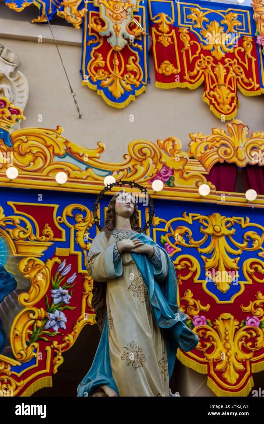 Cospicua, Malta - 1 dicembre 2024. Festa religiosa colorata processione con decorazioni ornate e partecipanti Foto Stock