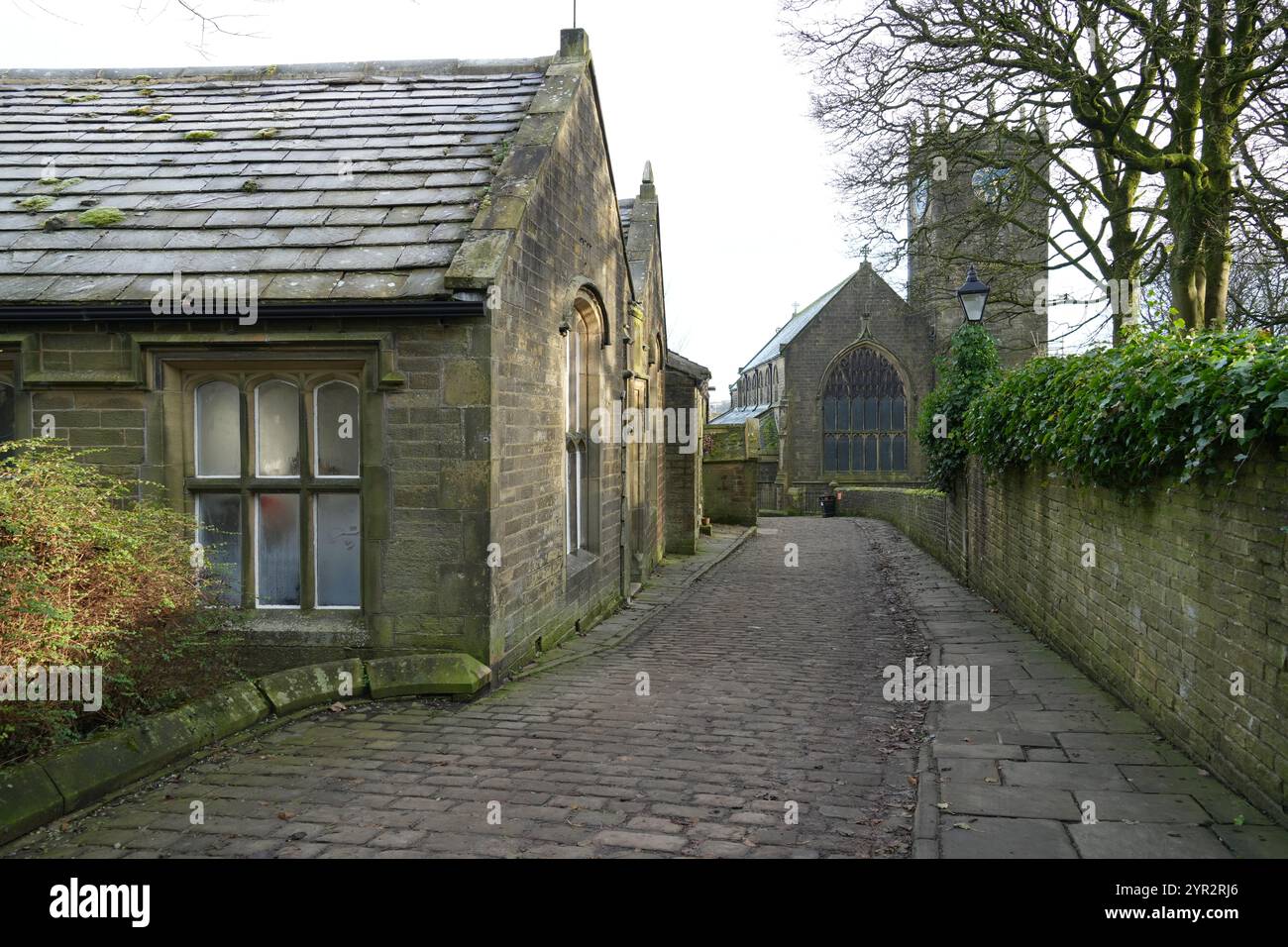 La Old School Room e la Chiesa di San Michele e di tutti gli Angeli sulla Chiesa acciottolata di St Foto Stock