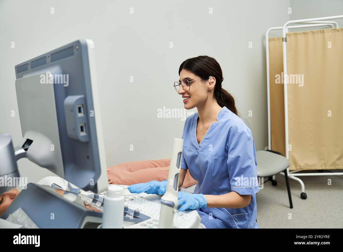 Un ginecologo interagisce con un paziente, fornendo assistenza professionale e diagnostica sanitaria. Foto Stock