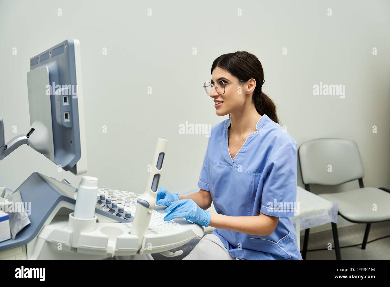 Un ginecologo esperto lavora diligentemente al suo computer analizzando i dati sulla salute femminile in una clinica. Foto Stock