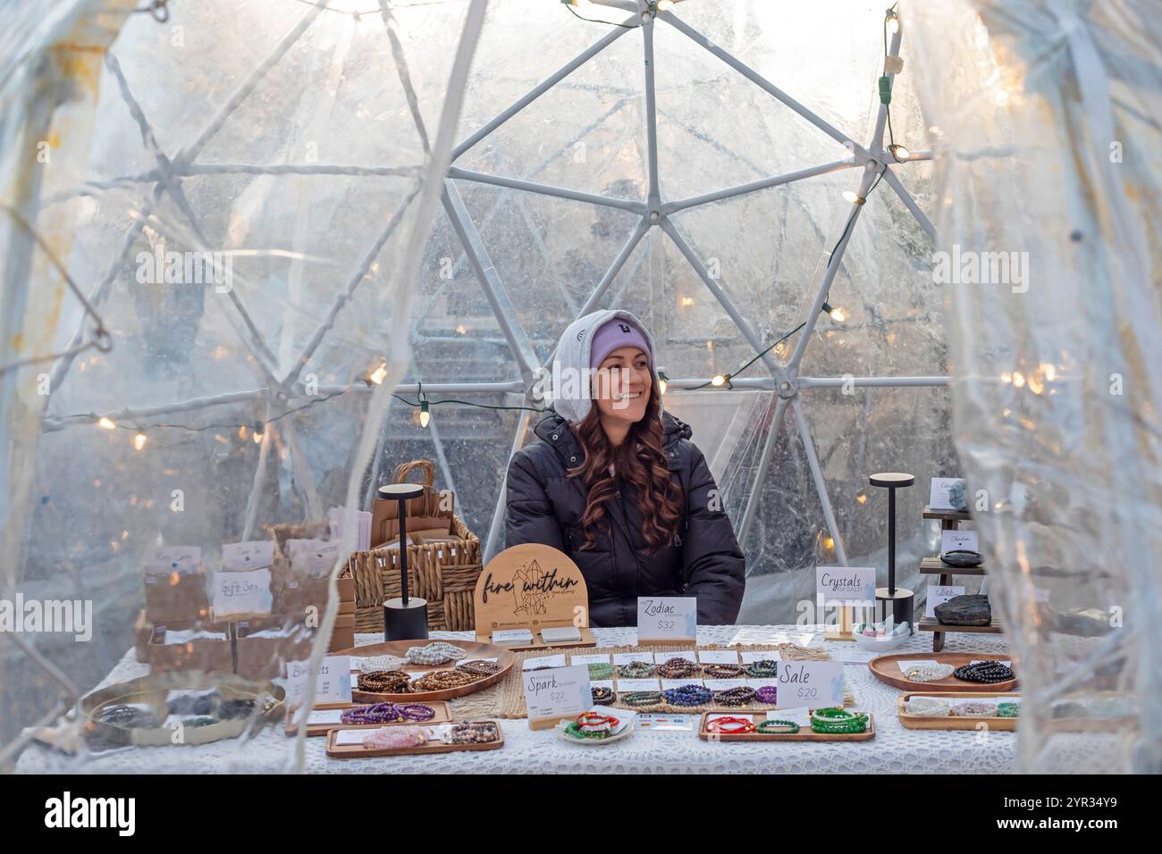 London, Ontario, Canada - Una donna vende bracciali e altri oggetti in un rifugio fuori dal mercato di Covent Garden. Fondata nel 1845, il mercato giornaliero è fuori uso Foto Stock