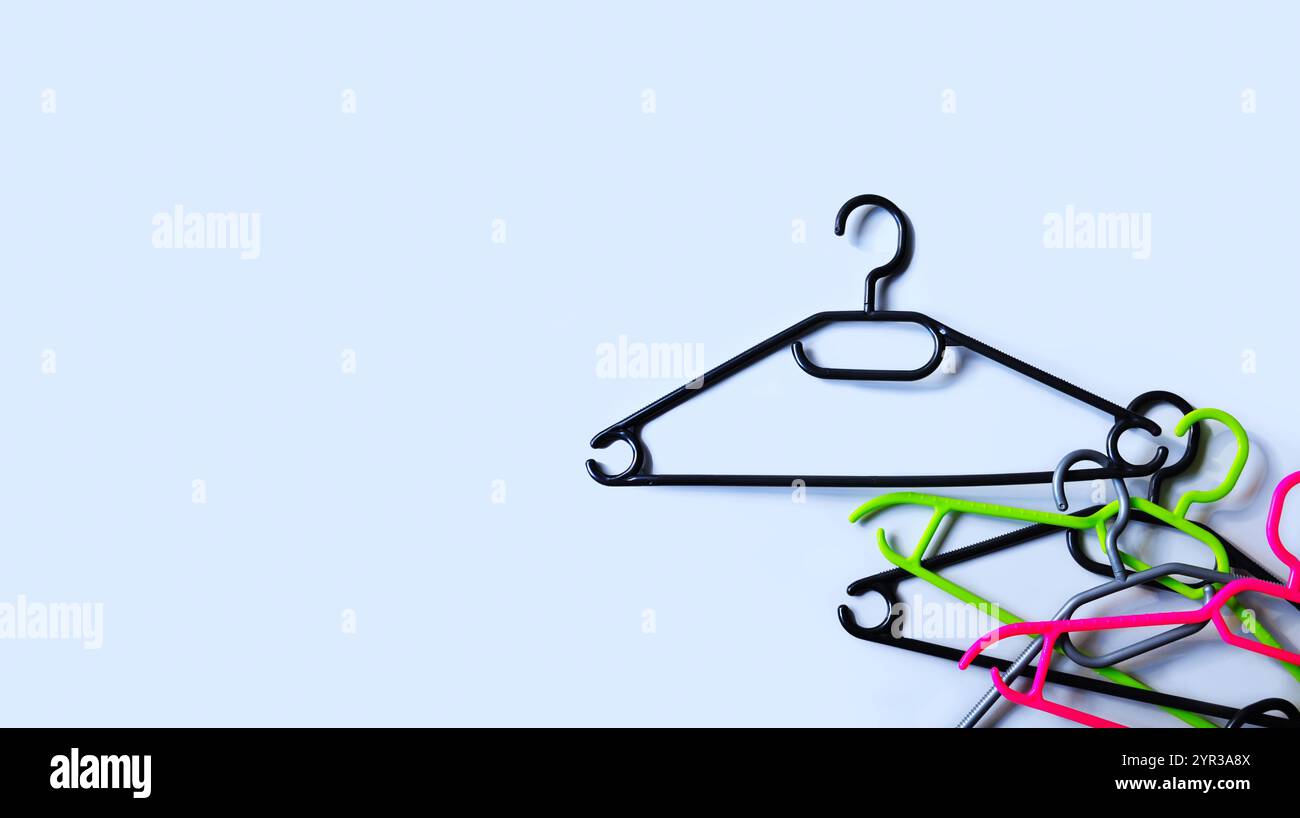 Appendiabiti in plastica. Vendite, sconti, shopping. Appendiabiti vuoti impilati su sfondo grigio chiaro. Minimalismo Foto Stock