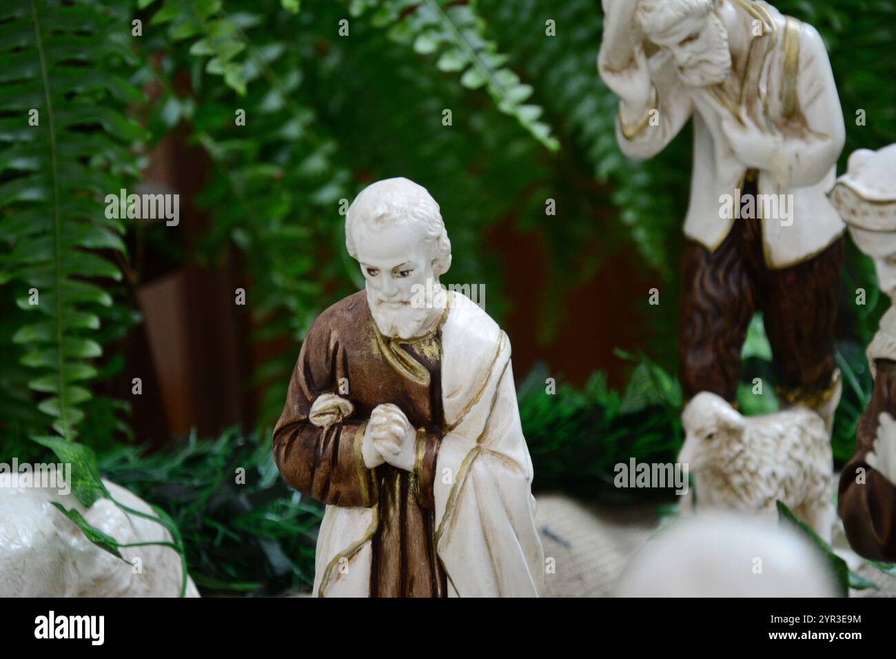 Figure di un presepe con un uomo sullo sfondo sfocato Foto Stock