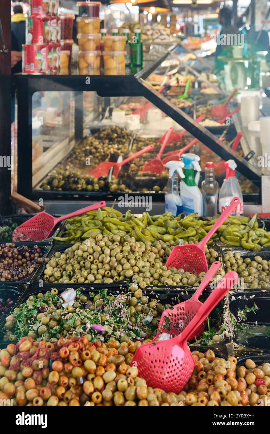 Un chiosco che vende varie olive e verdure marocchine nell'esotico mercato interno del sabato nel quartiere dei teatri del centro di Anversa Foto Stock