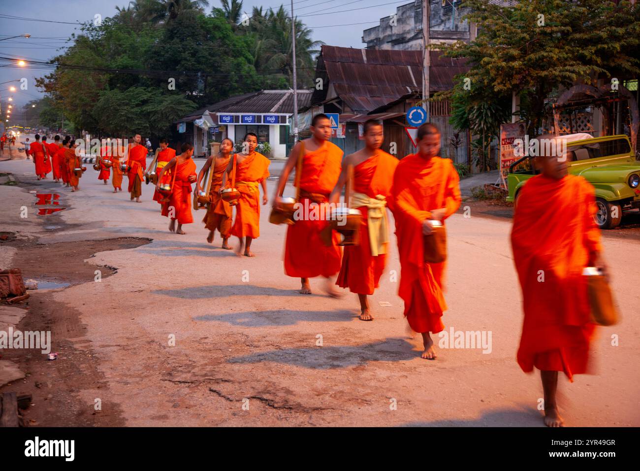 Luang Prabang, Laos - 9 aprile 2011: La processione mattutina dei monaci, a partire dalle 05:30: Monaci e novizi rivestiti di zafferano emergono sul Foto Stock