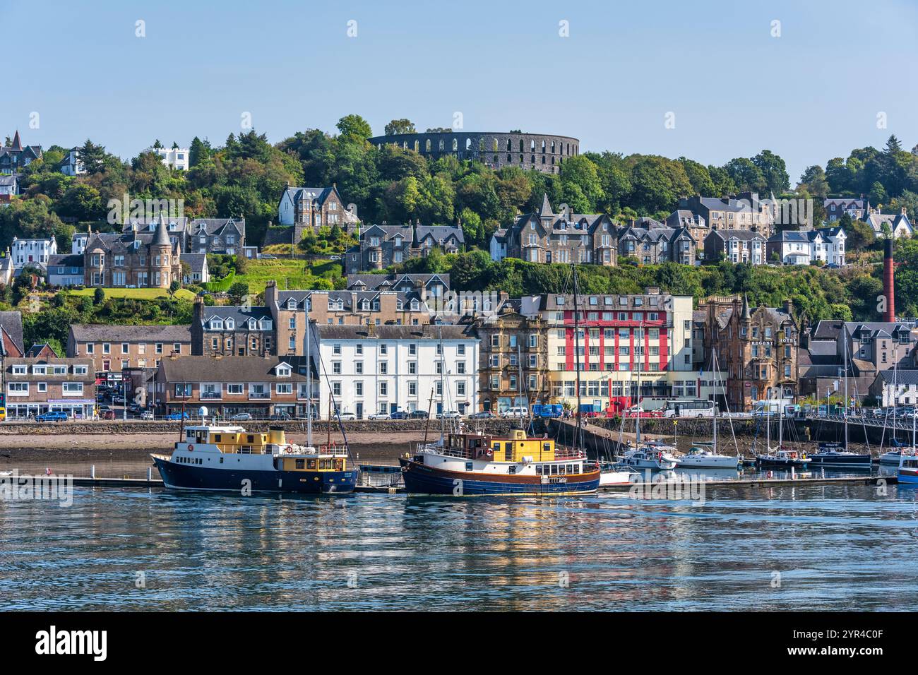 Porto e lungomare di Oban, con la Torre McCaig su Battery Hill che si affaccia sulla città, a Oban, Argyll e Bute, Scozia, Regno Unito Foto Stock