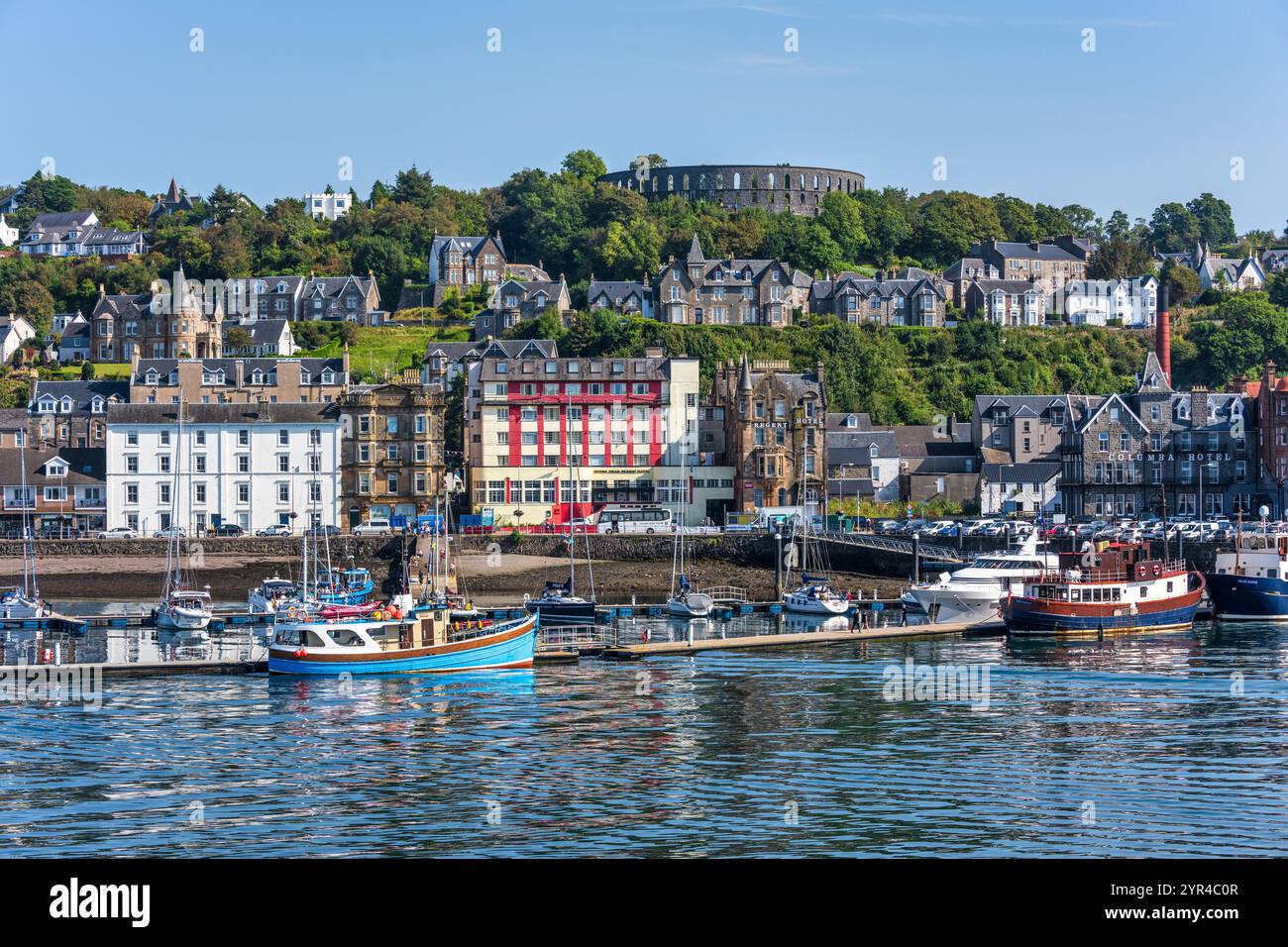 Porto e lungomare di Oban, con la Torre McCaig su Battery Hill che si affaccia sulla città, a Oban, Argyll e Bute, Scozia, Regno Unito Foto Stock