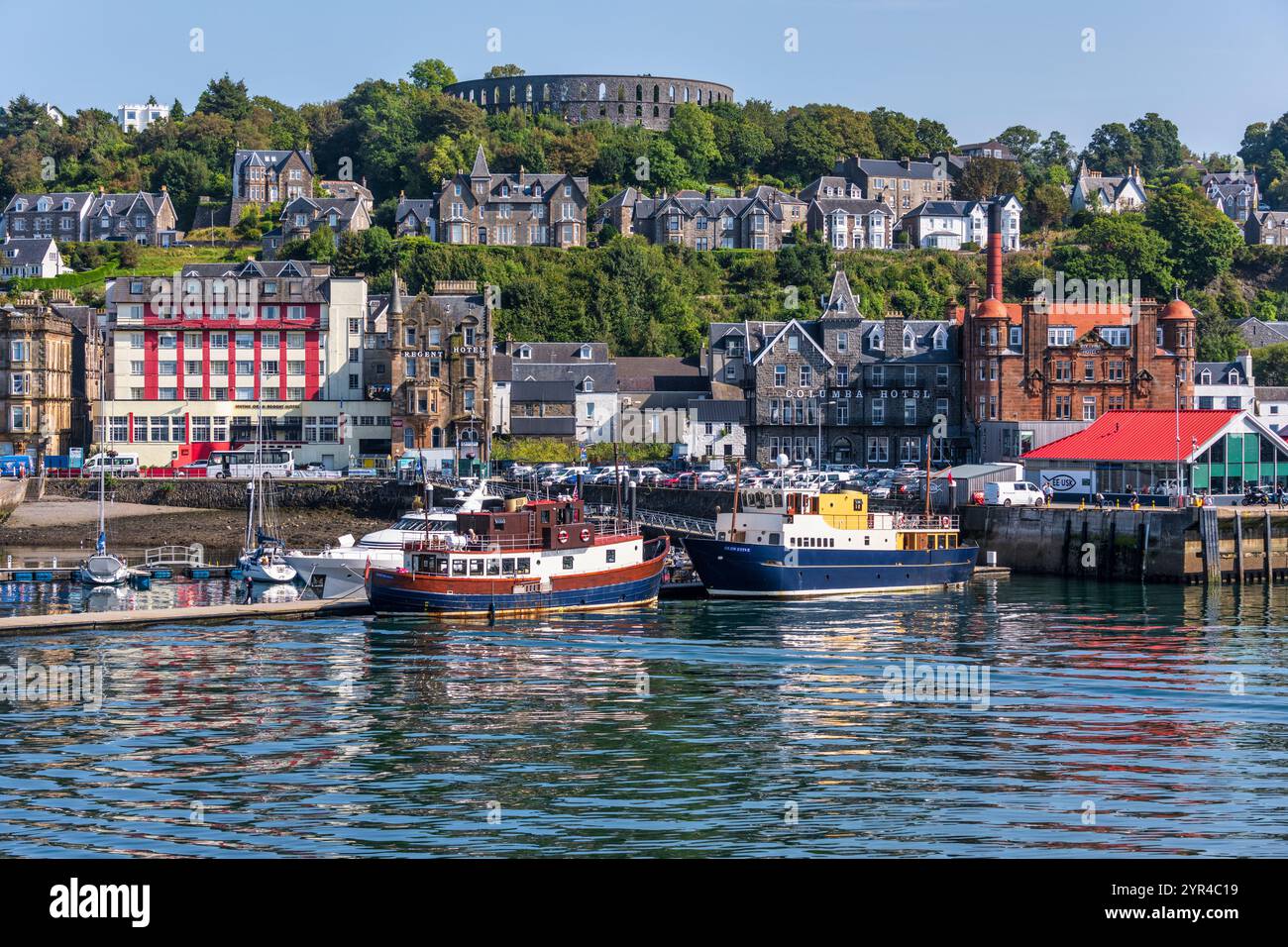 Porto e lungomare di Oban, con la Torre McCaig su Battery Hill che si affaccia sulla città, a Oban, Argyll e Bute, Scozia, Regno Unito Foto Stock