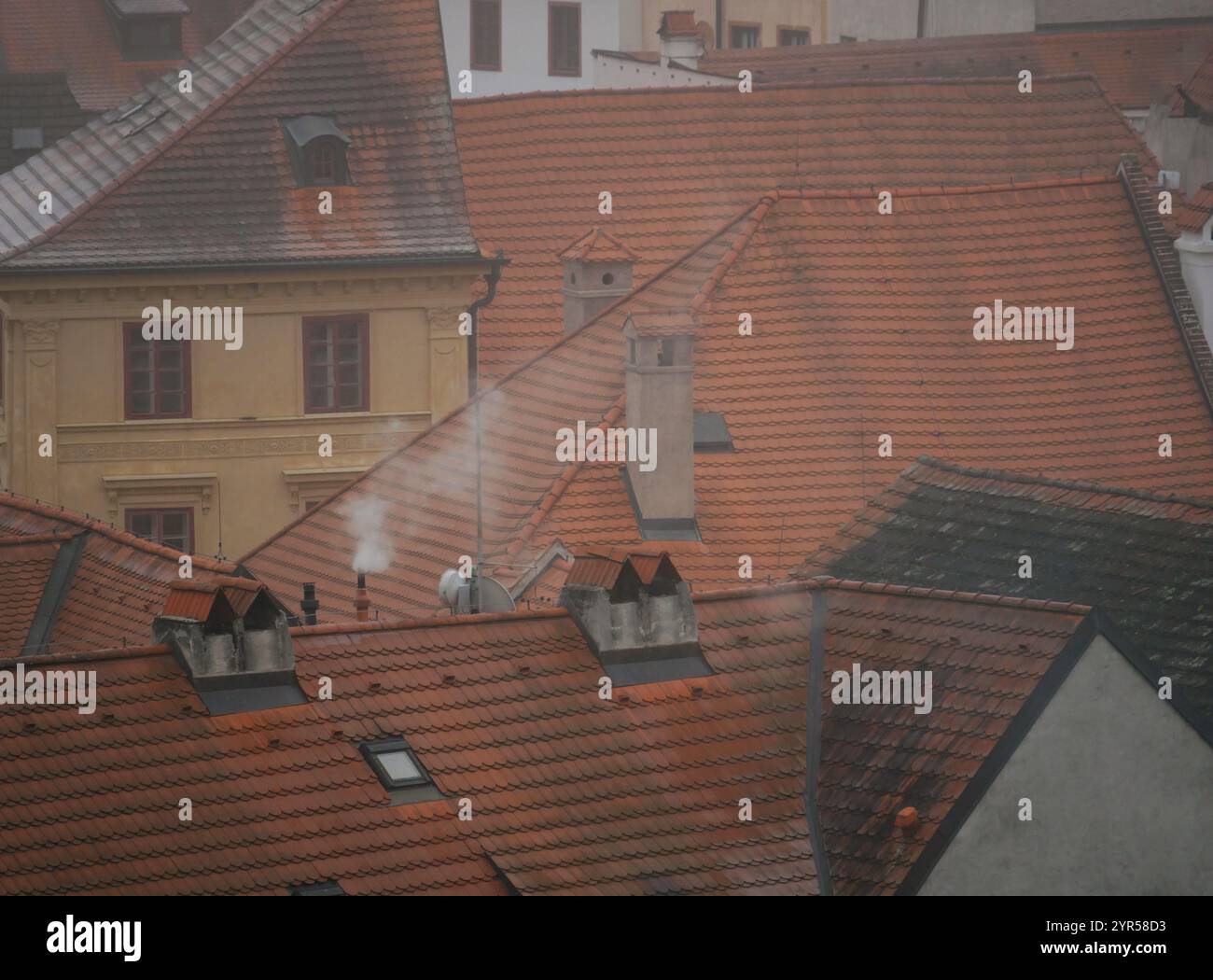 Fumo dalla vista dall'alto del camino. Stufa a legna in inverno a Cesky Krumlov, Repubblica Ceca. Inquinamento atmosferico concetto ambientale ecologico. Foto Stock