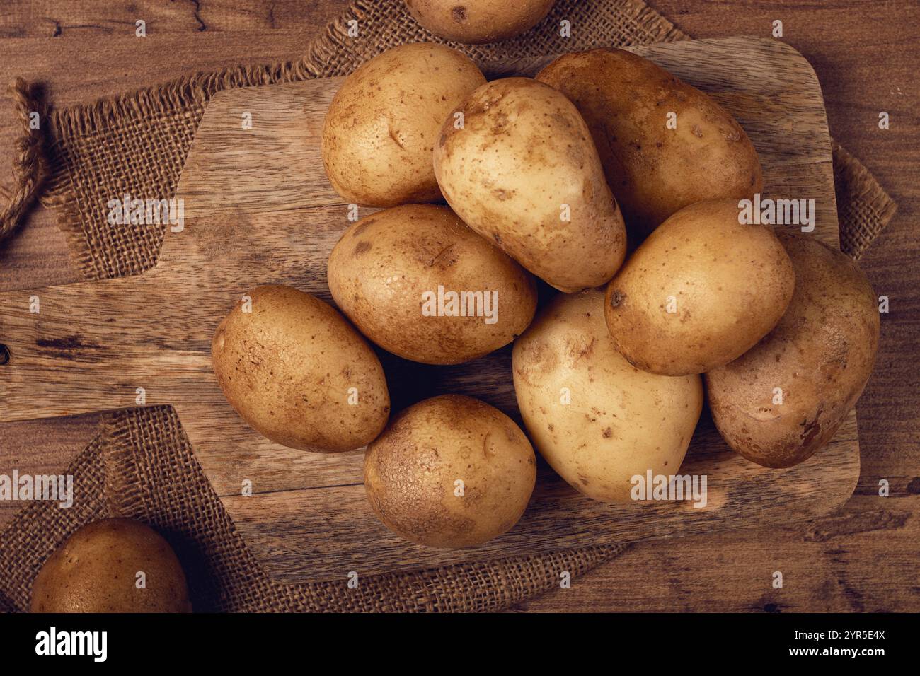 Patate crude, sparse su un tagliere, primo piano, nessuna gente Foto Stock