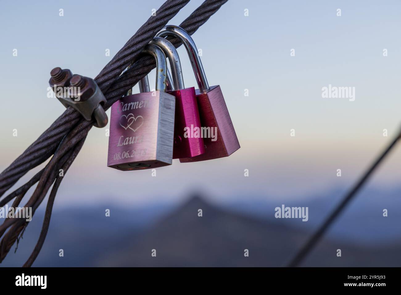 Due lucchetti appesi su una corda di metallo sullo sfondo di una montagna, simboleggiano un legame romantico, serratura d'amore, Salisburgo, Austria, Europa Foto Stock