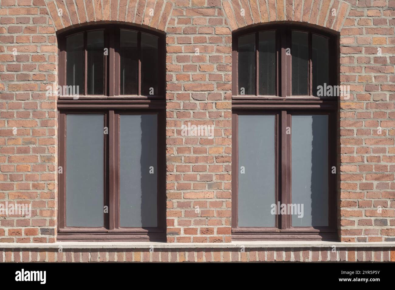 Vecchia finestra in un muro di mattoni di un vecchio edificio industriale Foto Stock