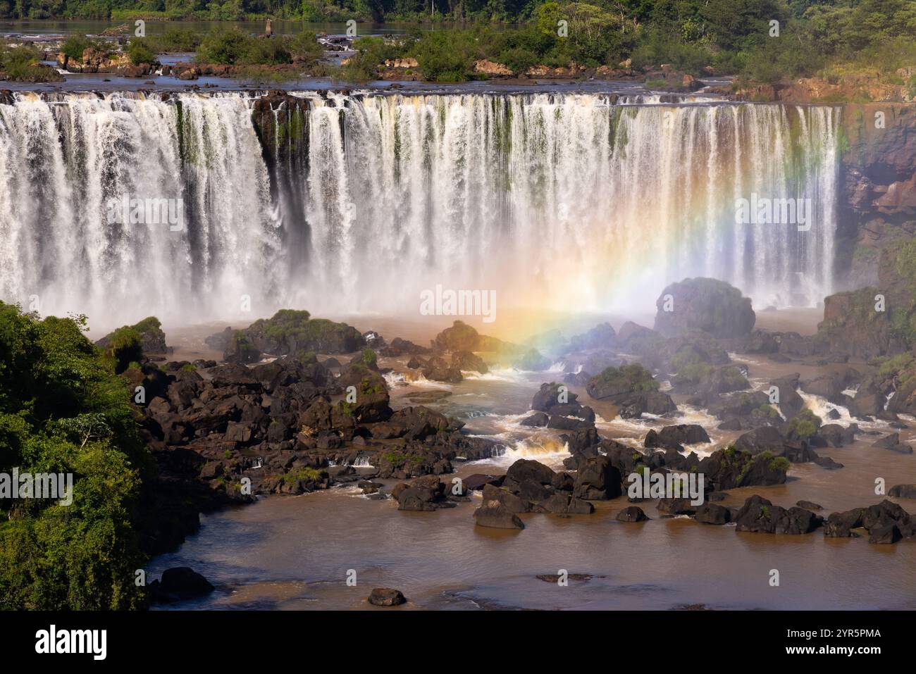 Cascate dell'Iguazú arcobaleno; vista al mattino dal lato del Brasile, un arcobaleno attraversa la cascata. Paesaggio naturale; le cascate dell'Iguazú viaggiano in Brasile Foto Stock