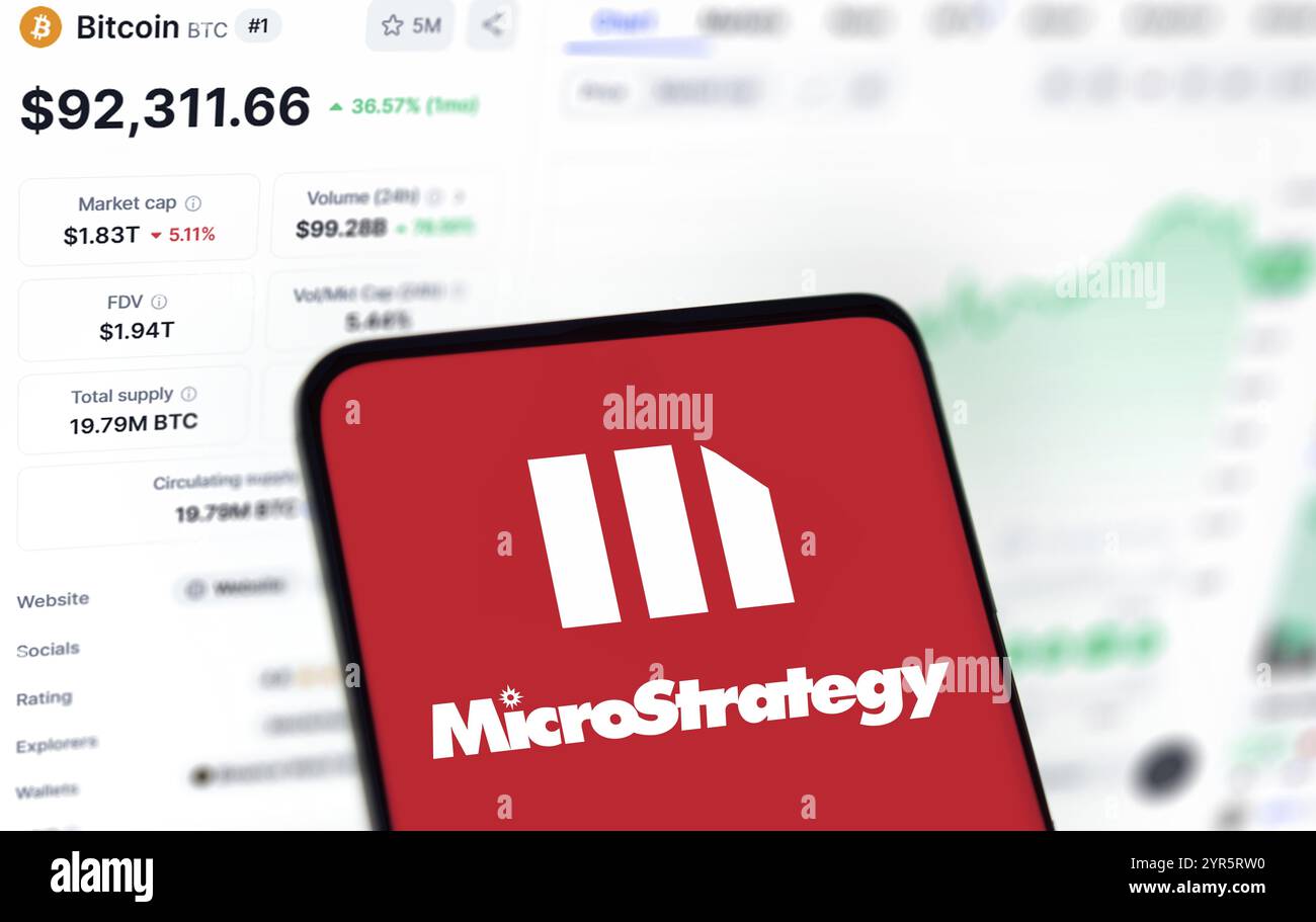 Il logo microstrategy viene visualizzato sullo smartphone e il prezzo Bitcoin sullo sfondo. Foto Stock