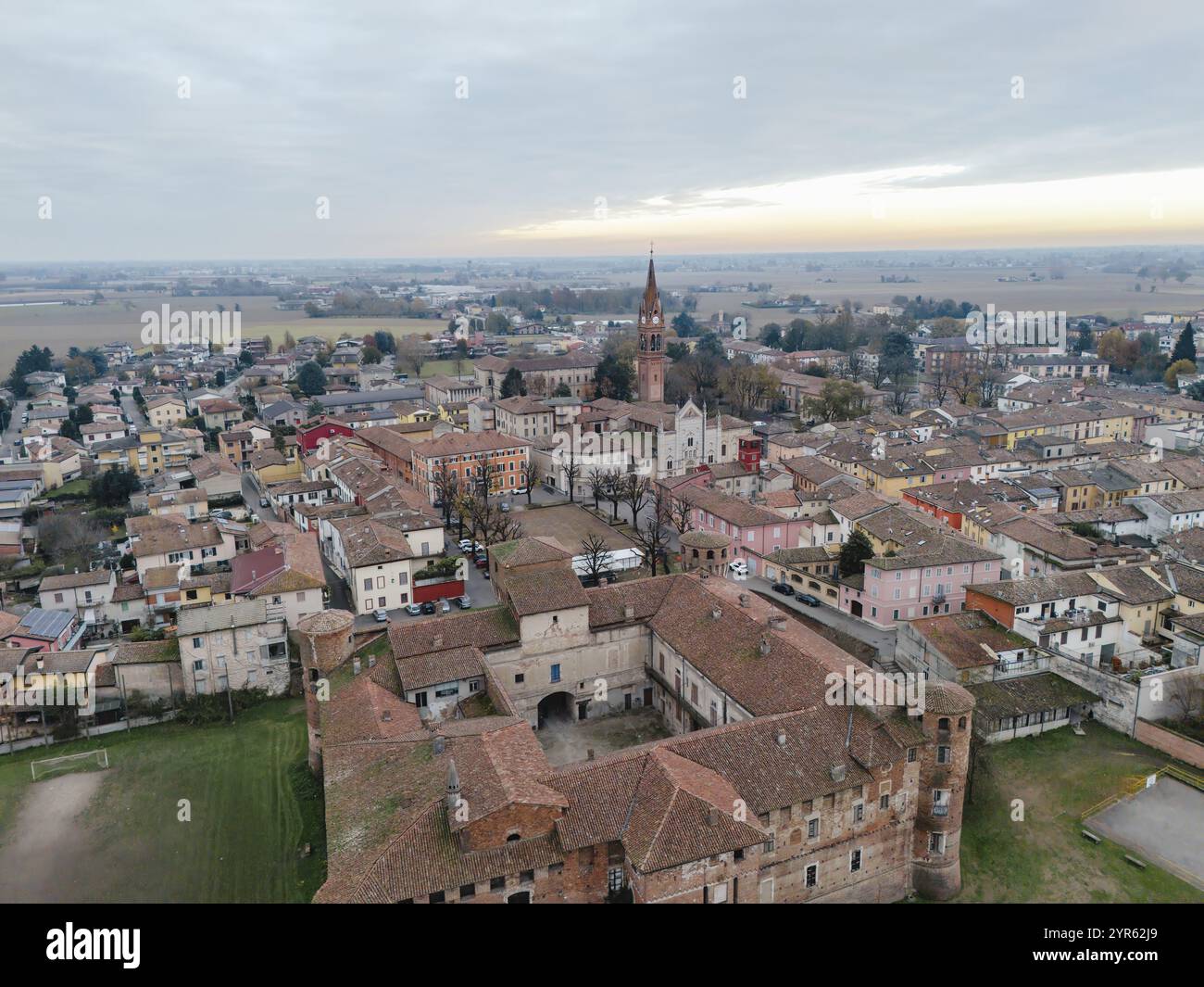 Vista aerea del castello medievale di rocca pallavicino casali e del villaggio di monticelli d'ongina, piacenza, provincia, italia, sotto un cielo nuvoloso Foto Stock