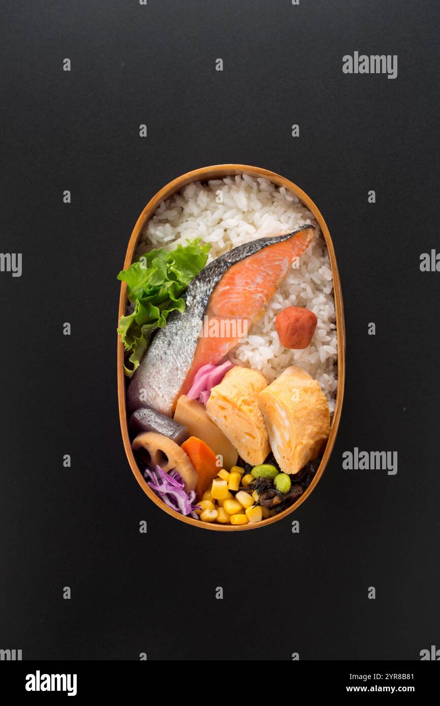 Cestino per pranzo di salmone con fondo nero, bento Foto Stock