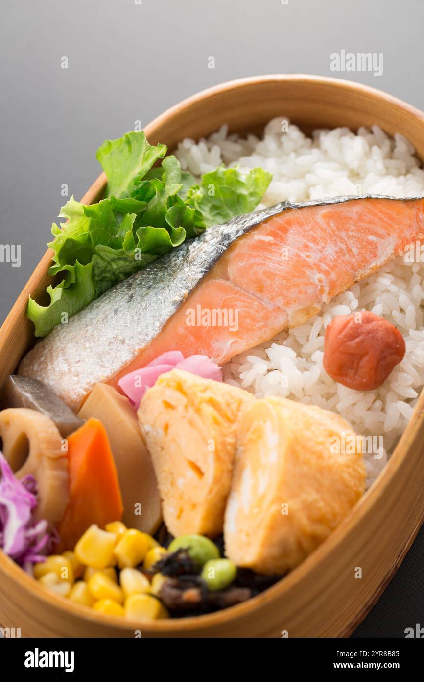 Cestino per pranzo di salmone con fondo nero, bento Foto Stock