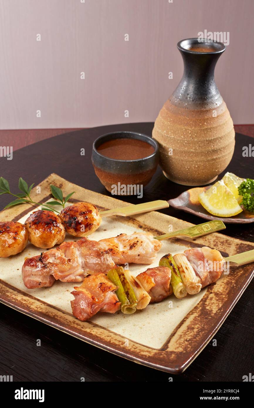 Yakitori di 3 tipi e sake freddo Foto Stock