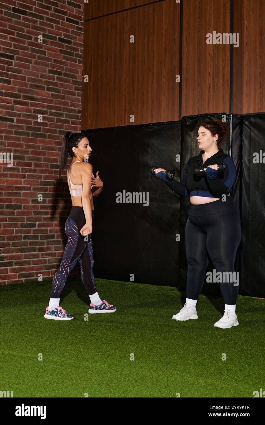 Le donne dimostrano tecniche di allenamento efficaci mentre si motivano a vicenda in palestra. Foto Stock
