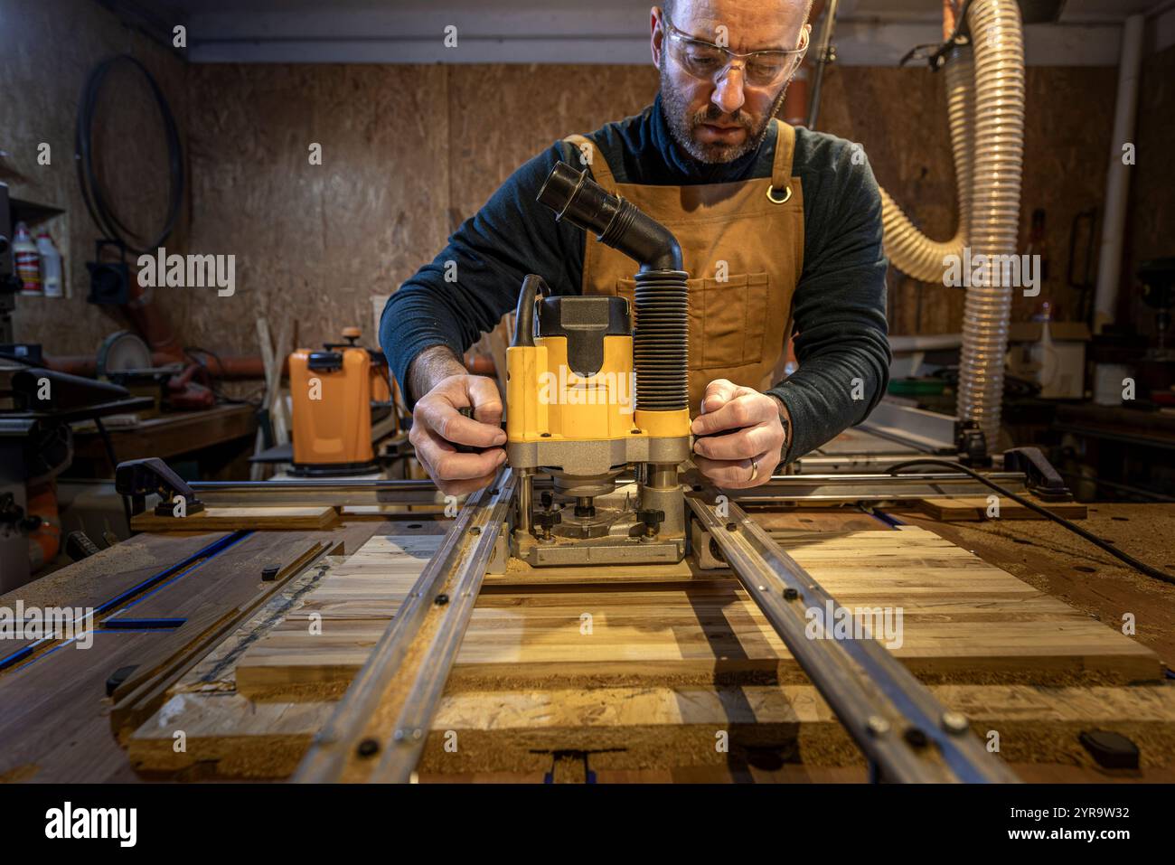 Artigiano caucasico che utilizza un utensile di fresatura in officina Foto Stock