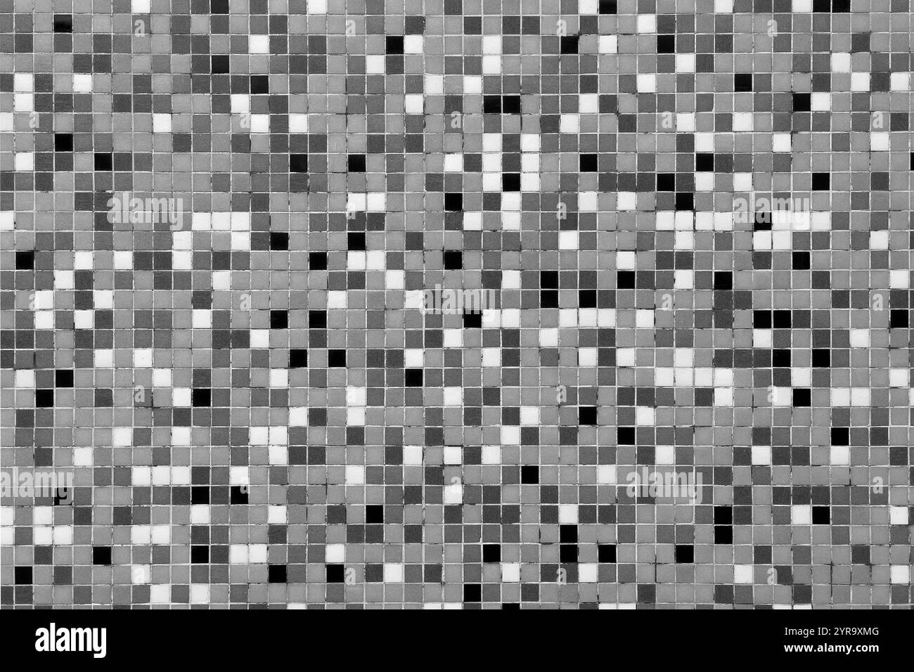 Parete a mosaico monocromatica con piccole piastrelle nere, bianche e grigie. Design simmetrico adatto per sfondi astratti o dettagli architettonici Foto Stock
