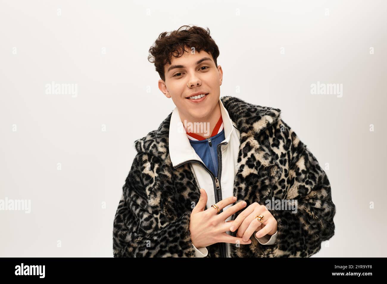Un uomo elegante con una giacca con stampa leopardata sorride, mostrando la sua moda disinvolta. Foto Stock