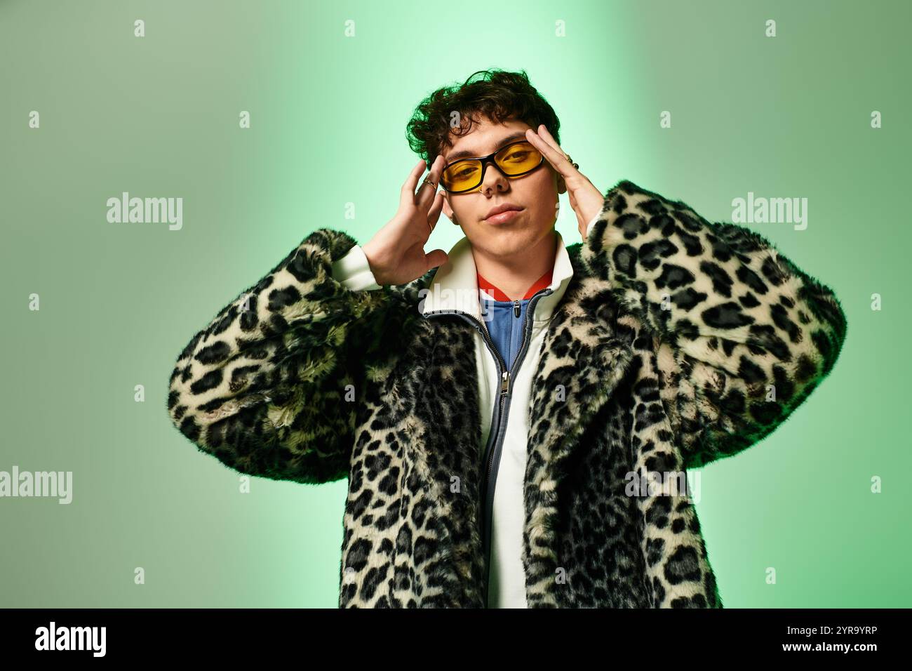 L'uomo sicuro di sé mette in mostra uno stile eclettico e accessori unici in un ambiente creativo. Foto Stock