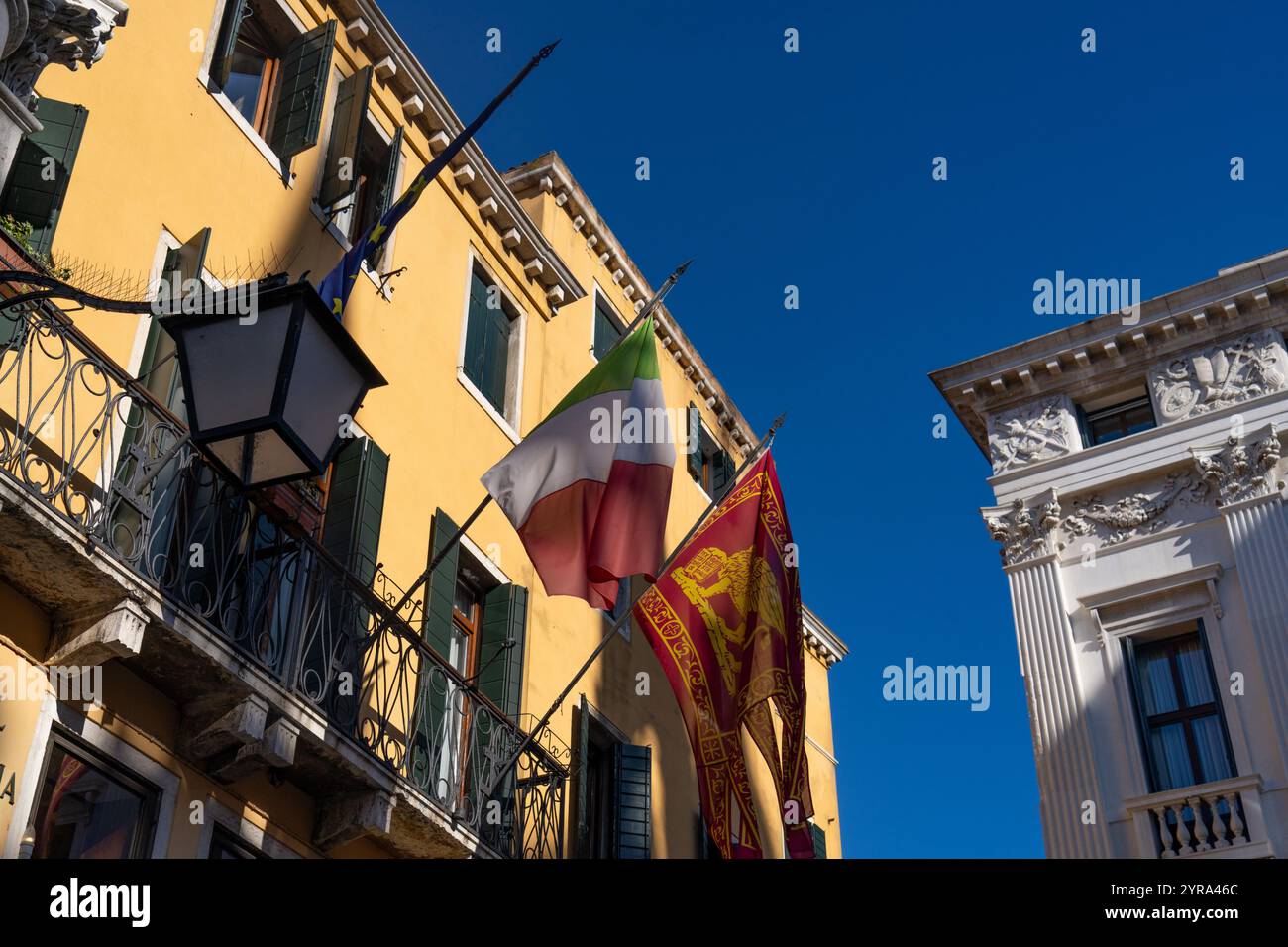 Bandiere d'Italia e Venezia in un edificio colorato a Venezia. La bandiera di San Marco era la bandiera dell'ex Repubblica di Venezia. Foto Stock