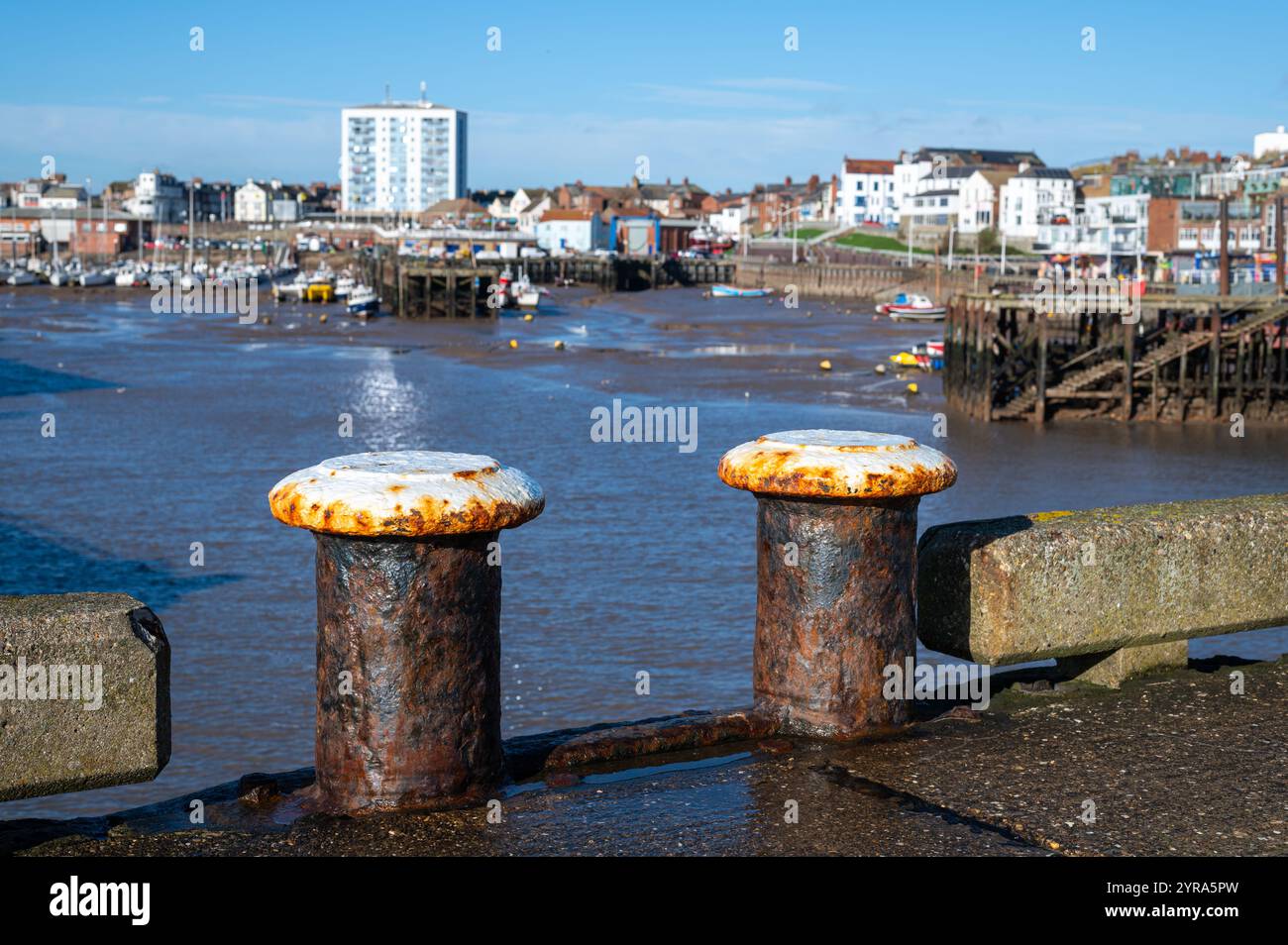 L'ormeggio di Rusty si trova sulla banchina di Bridlington Harbour, nell'East Yorkshire, con vista sul lungomare e sulle barche da pesca con la bassa marea in una giornata di sole Foto Stock