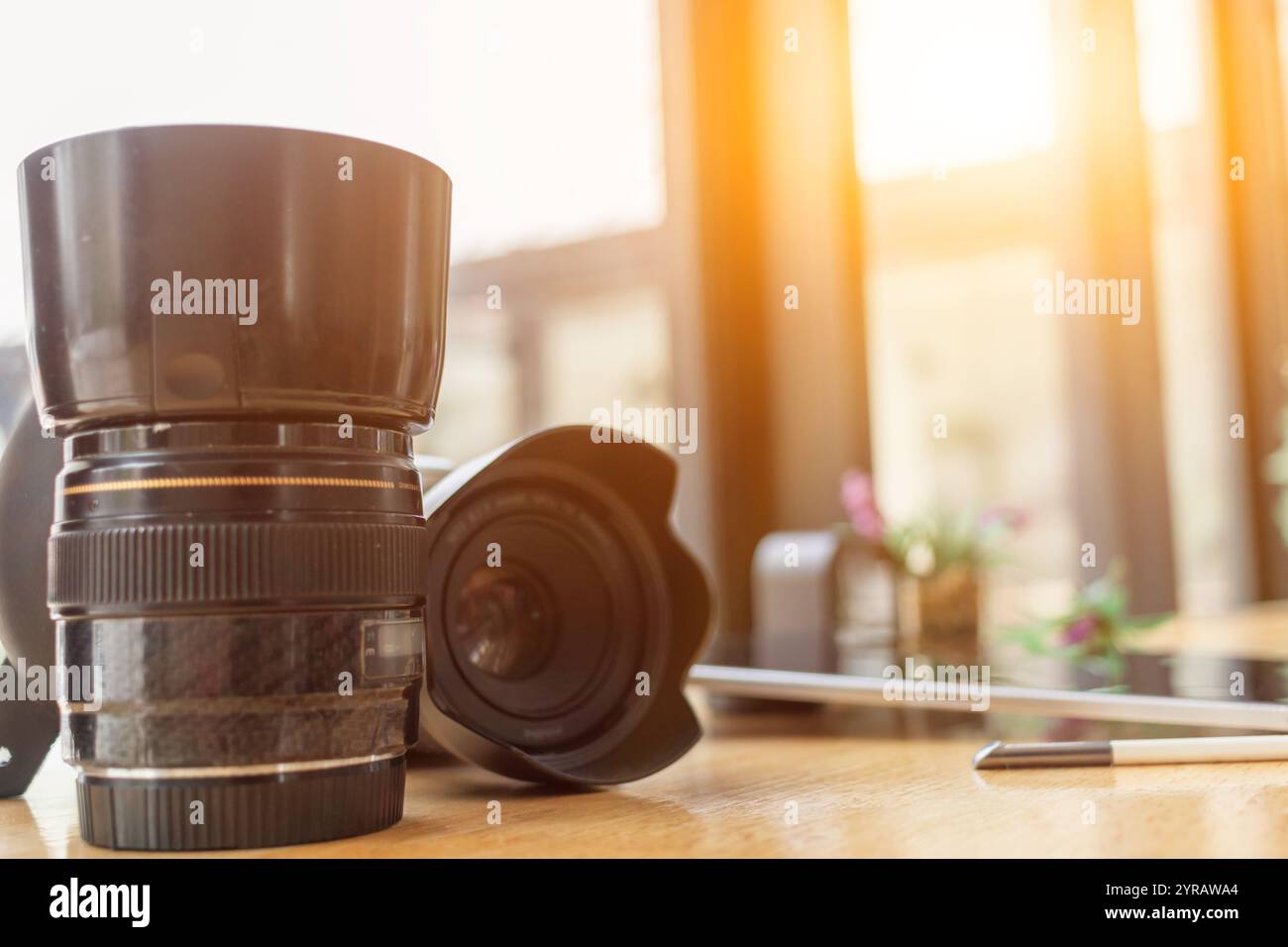 Una fotocamera DSLR viene posizionata accanto al computer sulla scrivania mentre il fotografo si prepara a trasferire le immagini dalla fotocamera al computer e all'edi Foto Stock