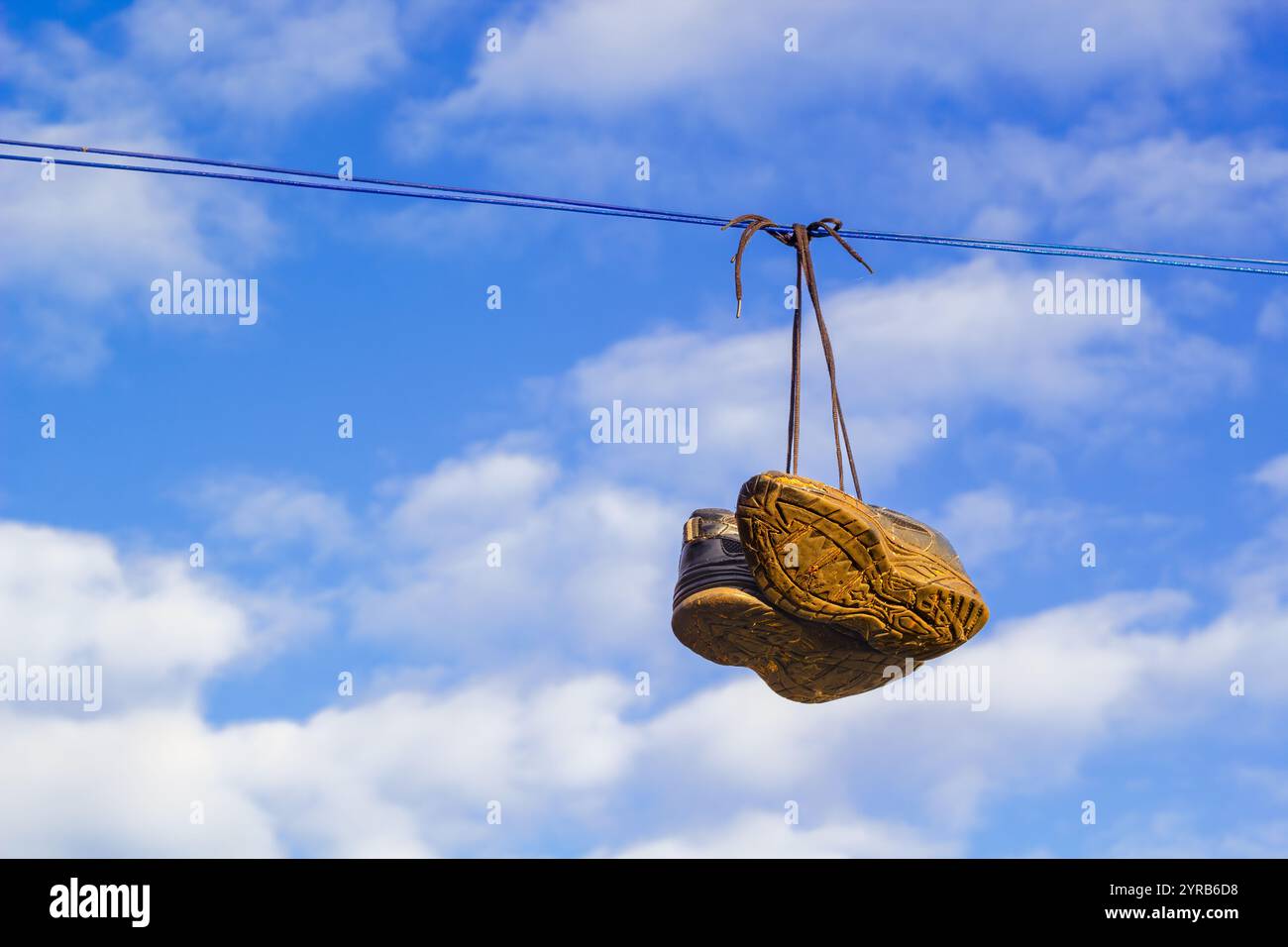 Scarpe sporche appese su una clothesline Foto Stock