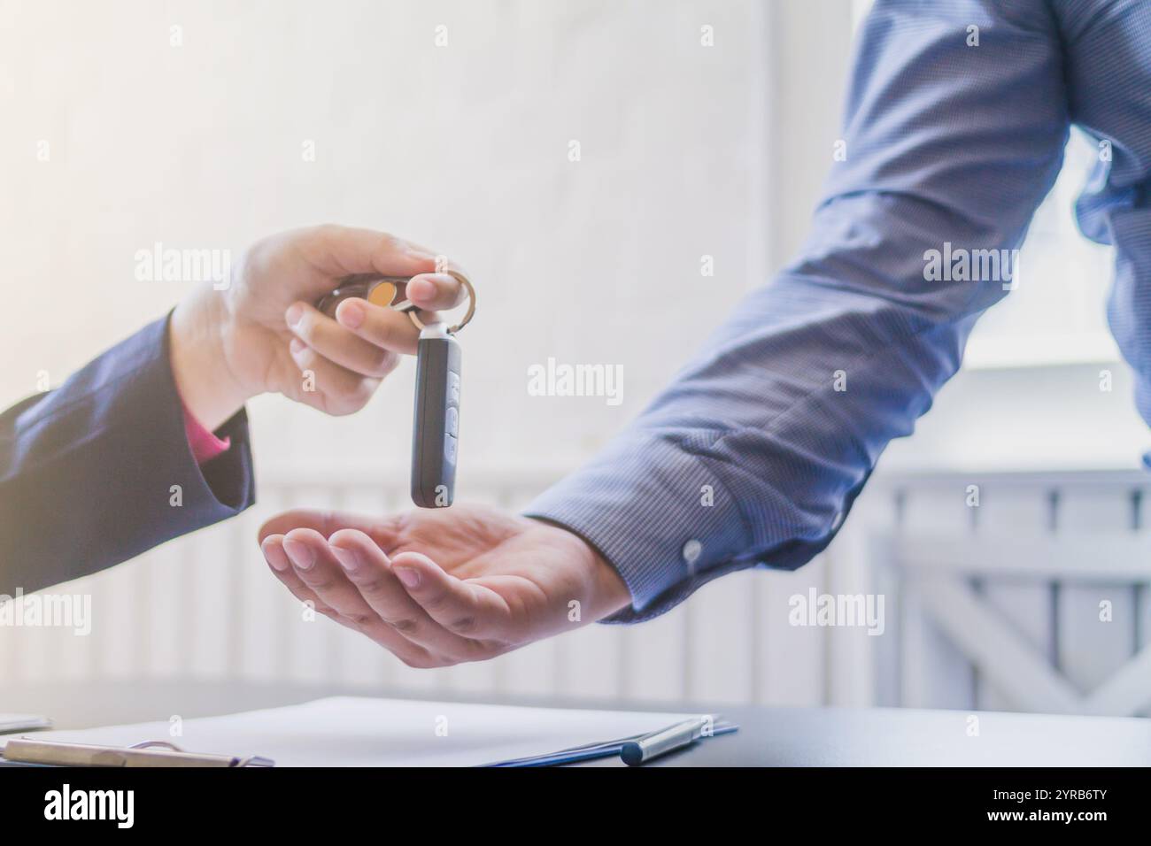 Il concessionario di auto consegna le chiavi all'acquirente dopo la firma del contratto di vendita. Consegnare le chiavi della vettura tra il concessionario e l'acquirente Foto Stock