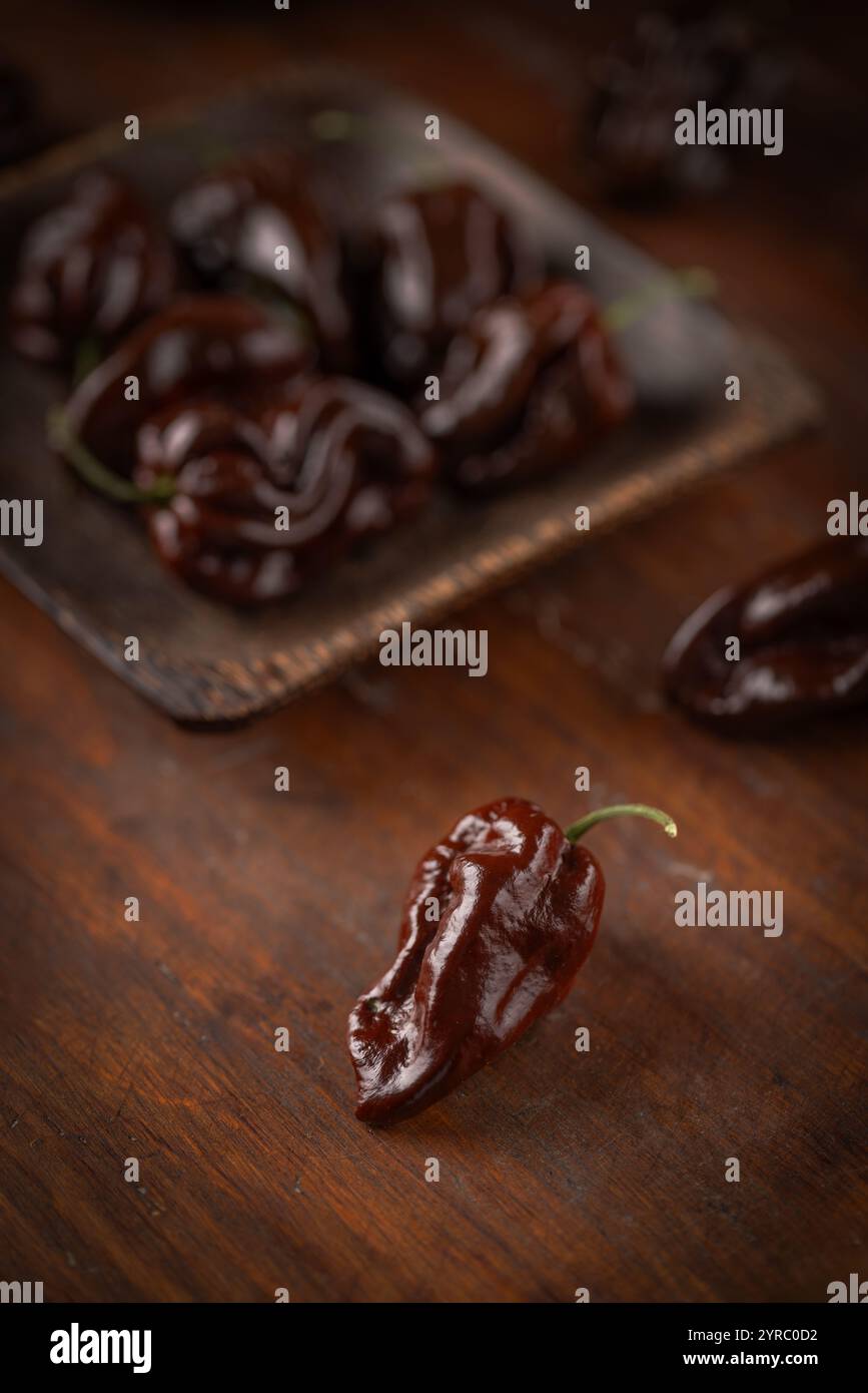 Peperoni habanero al cioccolato su una superficie in legno Foto Stock