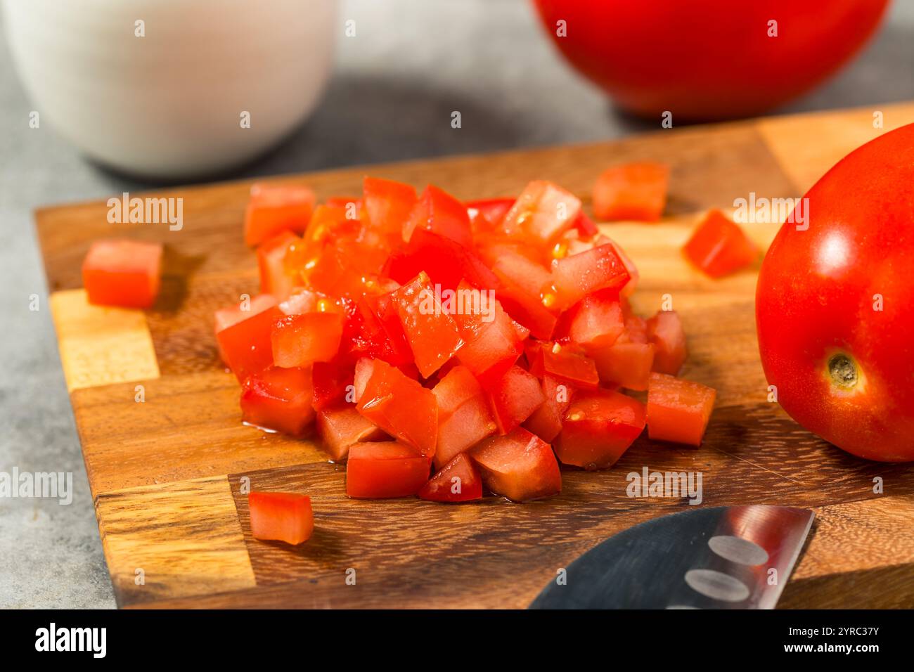 Pomodori biologici rossi crudi su un tagliere Foto Stock
