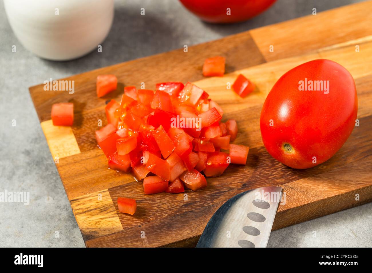 Pomodori biologici rossi crudi su un tagliere Foto Stock