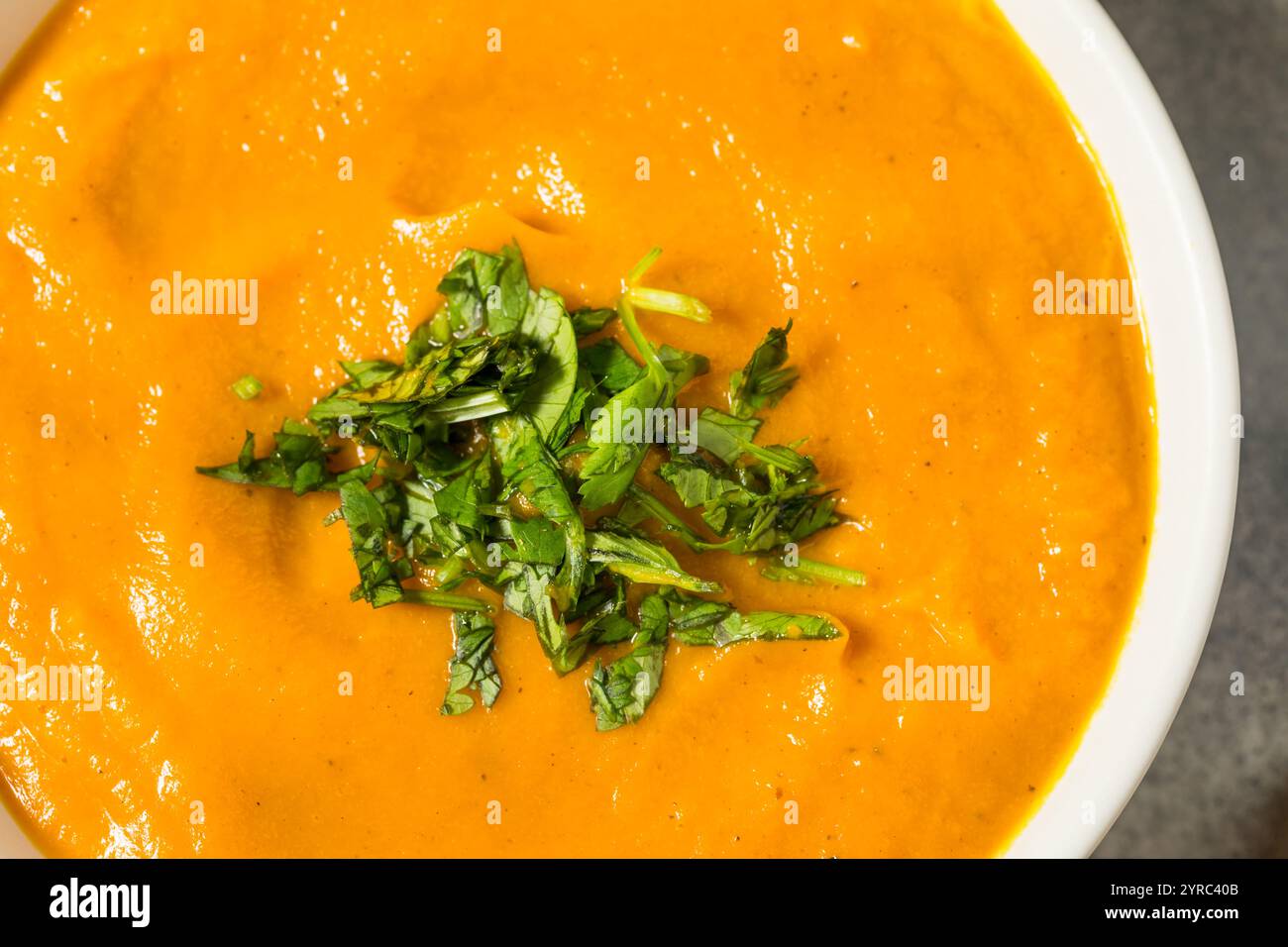 Sana zuppa cremosa di carote fatta in casa con prezzemolo in una ciotola Foto Stock