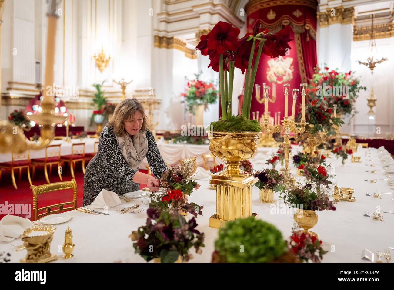 I ritocchi finali sono applicati ai fiori stagionali, da un fiorista reale, ai tavoli della sala da ballo di Buckingham Palace, Londra prima del banchetto di Stato per l'emiro del Qatar Sheikh Tamim bin Hamad al Thani, durante la sua visita di stato nel Regno Unito. Data foto: Martedì 3 dicembre 2024. Foto Stock