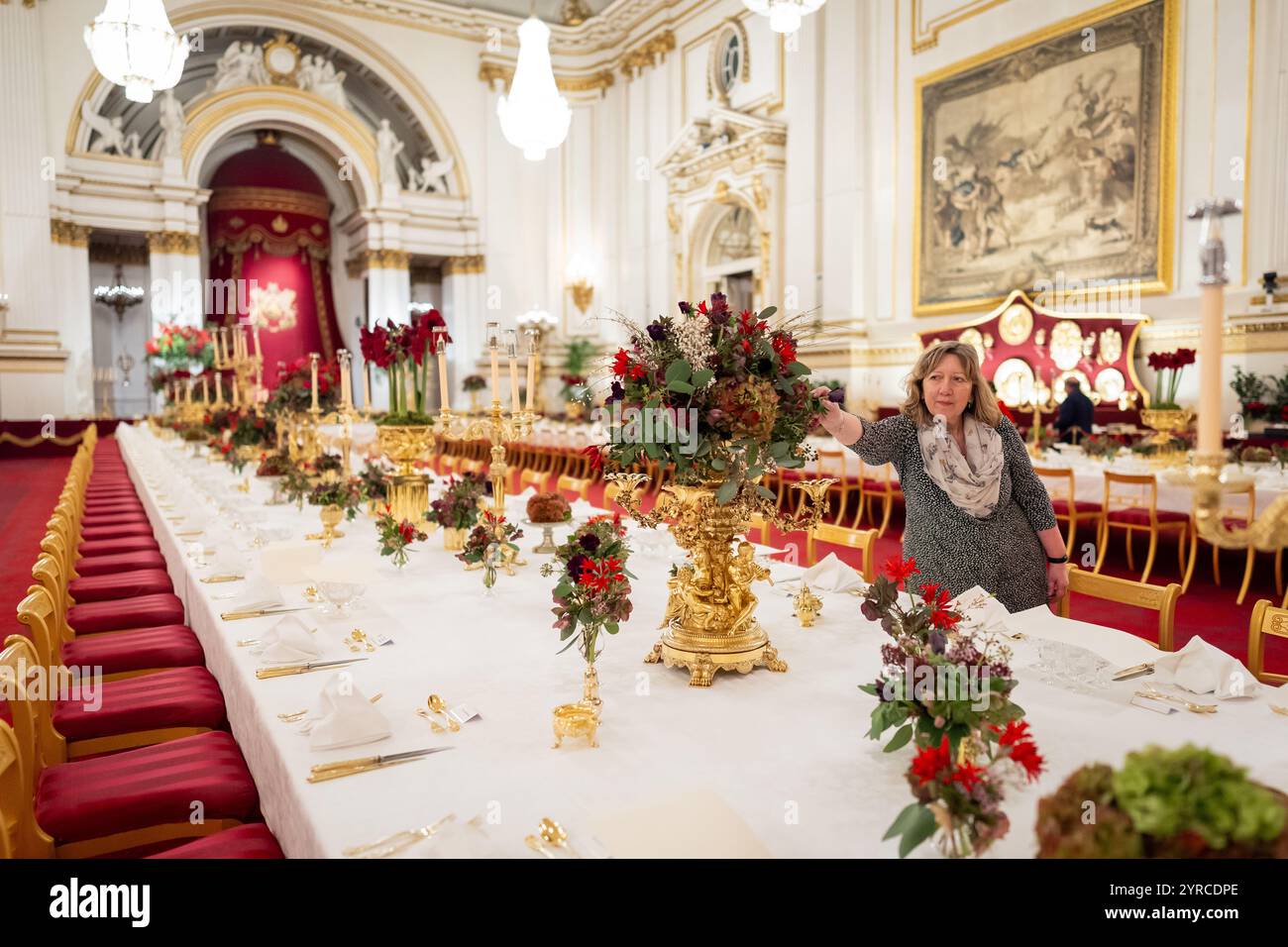 I ritocchi finali sono applicati ai fiori stagionali, da un fiorista reale, ai tavoli della sala da ballo di Buckingham Palace, Londra prima del banchetto di Stato per l'emiro del Qatar Sheikh Tamim bin Hamad al Thani, durante la sua visita di stato nel Regno Unito. Data foto: Martedì 3 dicembre 2024. Foto Stock