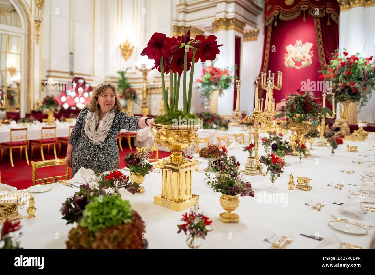 I ritocchi finali sono applicati ai fiori stagionali, da un fiorista reale, ai tavoli della sala da ballo di Buckingham Palace, Londra prima del banchetto di Stato per l'emiro del Qatar Sheikh Tamim bin Hamad al Thani, durante la sua visita di stato nel Regno Unito. Data foto: Martedì 3 dicembre 2024. Foto Stock