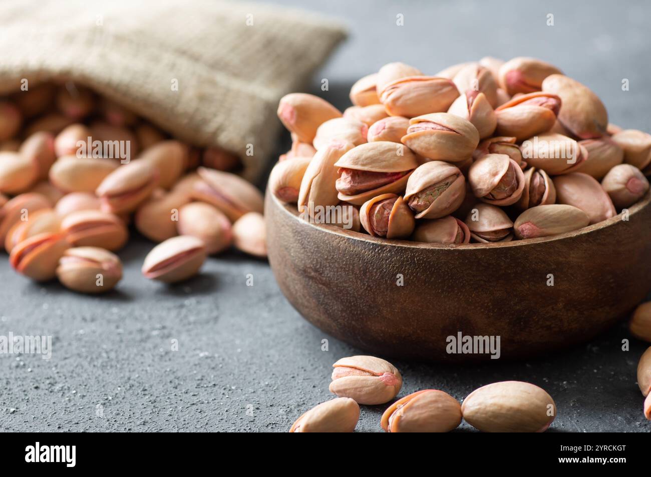Pistacchio noce in noce sullo sfondo rustico in ciotola, composizione di pistacchi ottimo per una nutrizione sana e dietetica. Concetto di dadi Foto Stock