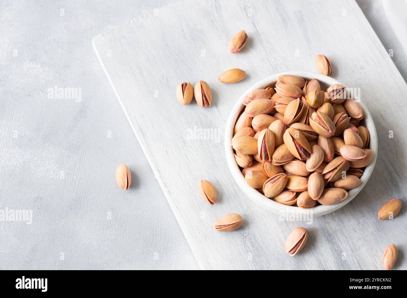 Pistacchio noce in noce sullo sfondo rustico in ciotola, composizione di pistacchi ottimo per una nutrizione sana e dietetica. Concetto di dadi Foto Stock